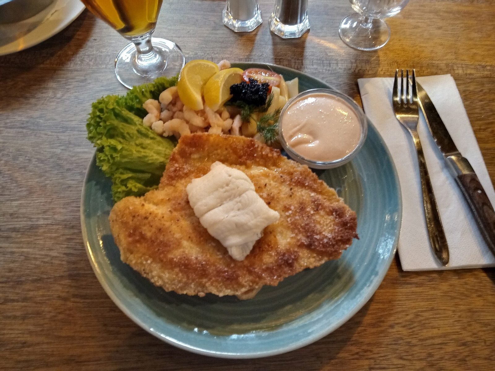 Stjerneskud auf einem Teller: gebratenes Schollenfilet mit Krabben, Salat, Zitrone und Rogen auf geröstetem Brot